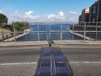 Road by sea against sky in city