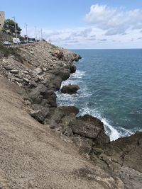 Rock formation on beach against sky