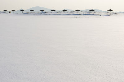 Scenic view of snowed beach against sky during winter