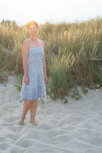 Portrait of young woman standing at beach