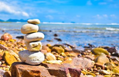 Stack of pebbles on beach against sky