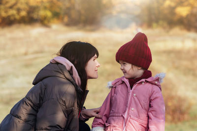 Happy and smilling mother and daughter in nature. family, parenting and healthy relationship concept