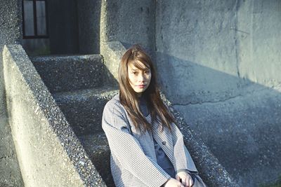 Portrait of young woman sitting on steps