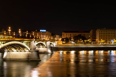 Illuminated bridge over river at night