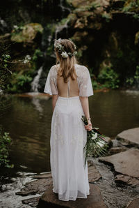 Rear view of woman standing by lake