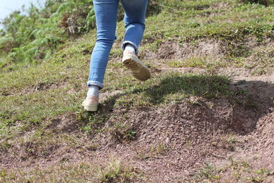 Low section of man walking on field