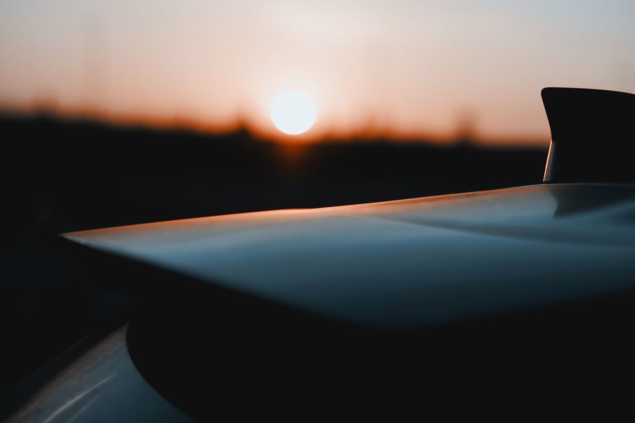 CLOSE-UP OF CAR AGAINST SUNSET SKY