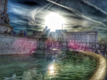 People swimming in pool against sky