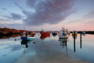 Sailboats moored at harbor