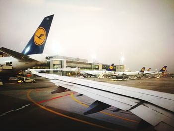 Airplane on airport runway against sky