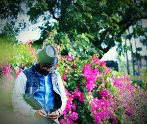 Man standing against flowers