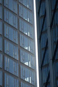 Low angle view of glass building against sky