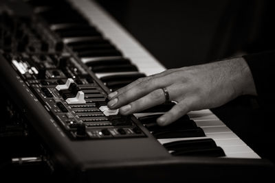 Cropped hands of man playing piano