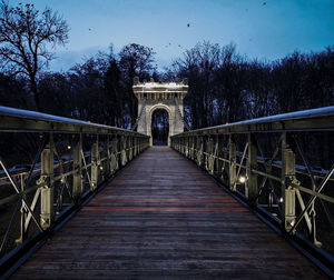 Footbridge leading to bridge against sky