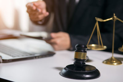 Midsection of man using mobile phone on table