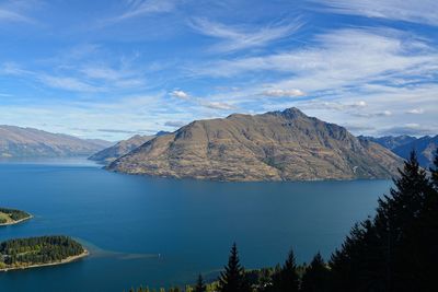 Scenic view of lake and mountains against blue sky