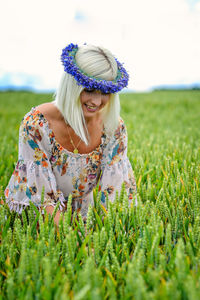  beautiful woman wearing floral headwear at field