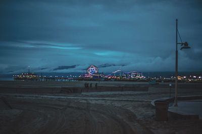 View of illuminated city against cloudy sky