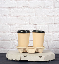 White cardboard box with pizza and disposable paper cups with coffee in holder, delivery concept