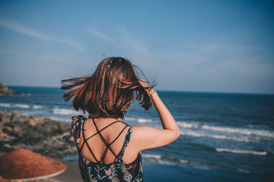 Rear view of person looking at sea against sky