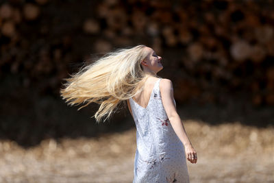 Rear view of young woman with tousled hair outdoors