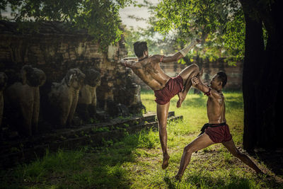 Shirtless warriors fighting on field