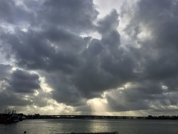 Scenic view of river against storm clouds