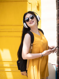 Smiling young woman wearing sunglasses standing outdoors