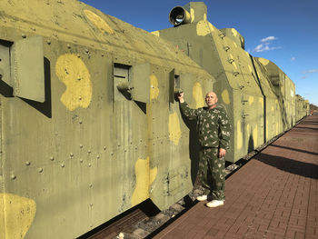 Full length of boy standing against yellow wall