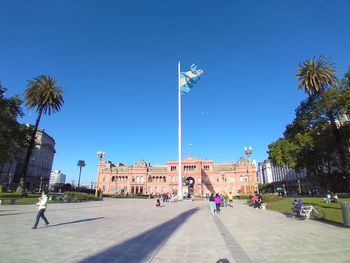 Palm trees and buildings against blue sky