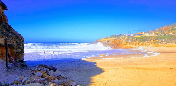 Scenic view of beach against blue sky