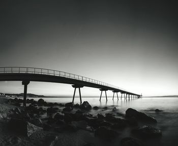 Bridge over sea against clear sky