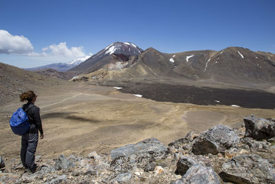 Male hiker looking at scenic landscape of a lava field and a volcano