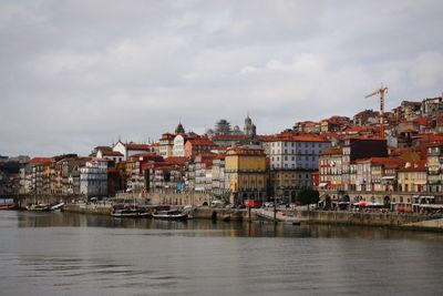 Buildings by sea against sky in city