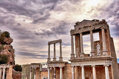 Low angle view of old ruin building against cloudy sky