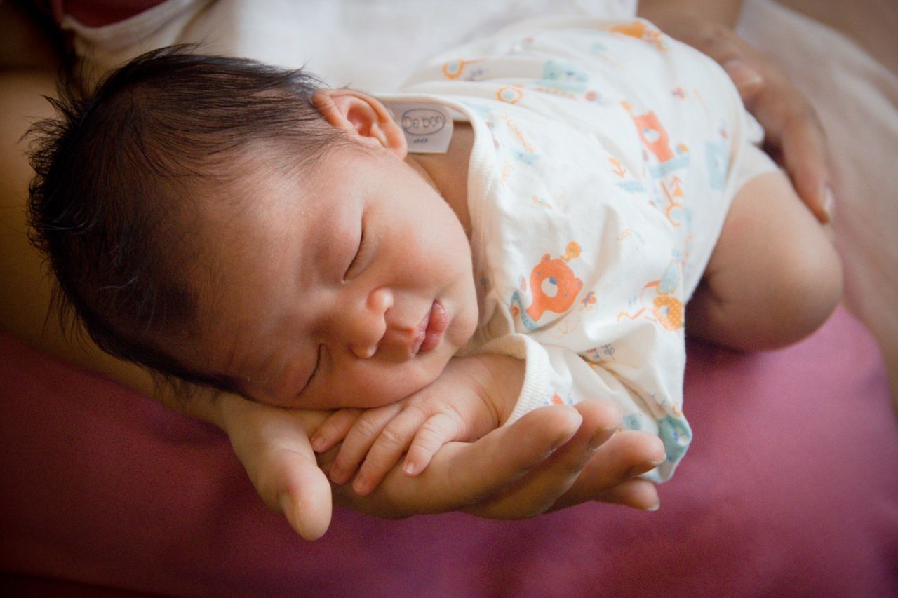 CLOSE-UP OF BABY SLEEPING IN BED