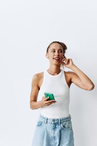 Portrait of young woman standing against white background