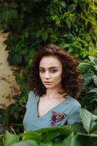 Portrait of beautiful teenage girl standing amidst plants