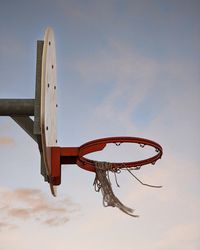 Low angle view of metallic basketball hoop against sky