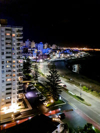 High angle view of illuminated street amidst buildings at night