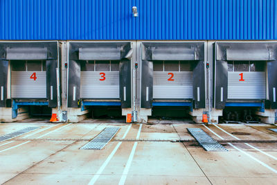 Loading ramps with numbers on closed shutter doors and empty space in front of storage docks