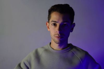 Close-up portrait of young man standing by wall