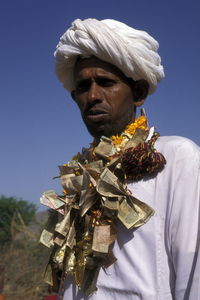 Man wearing necklace made by paper currency