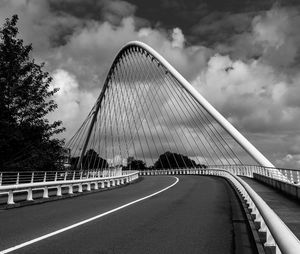 View of suspension bridge against cloudy sky