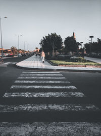 Vehicles crossing road against clear sky