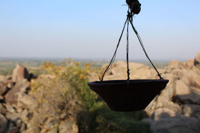 Close-up of drink on rock against sky