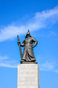 Low angle view of statue against blue sky