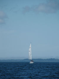 Sailboat sailing on sea against sky