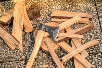 Preparation of wood to light a fire to cook food on grill outdoor. ax and pieces of firewood