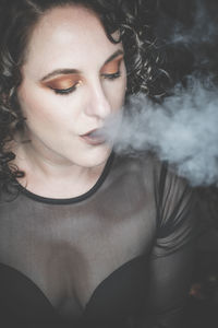 Close-up portrait of young woman smoking